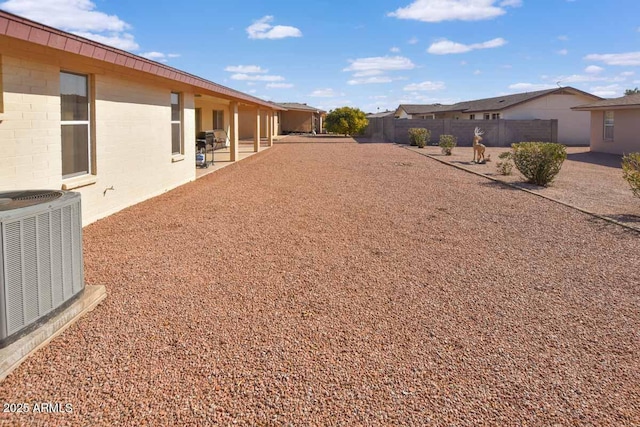 view of yard with central AC unit and a patio