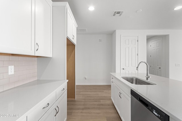 kitchen featuring stainless steel dishwasher, white cabinets, and sink