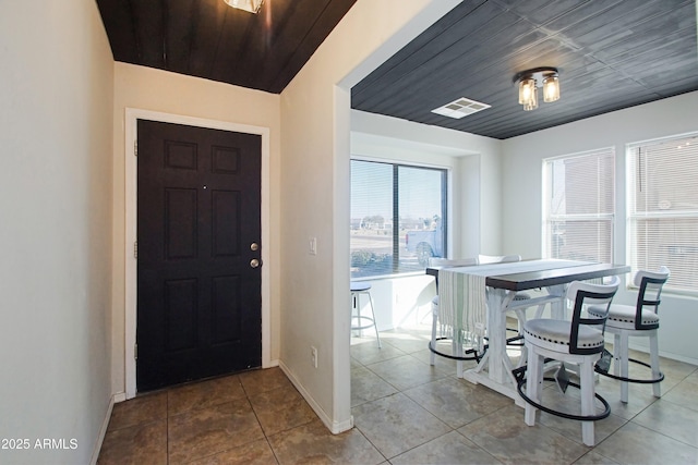 tiled foyer entrance with wood ceiling