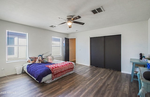 bedroom featuring dark hardwood / wood-style floors, ceiling fan, and a closet