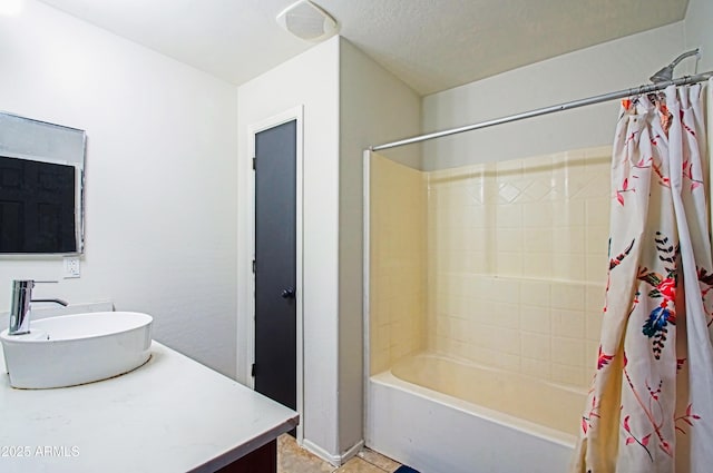 bathroom with vanity, shower / bathtub combination with curtain, and a textured ceiling