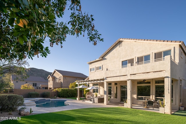 back of property with a patio, a yard, an outdoor hangout area, ceiling fan, and a fenced in pool