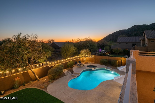 pool at dusk with a mountain view and a patio area