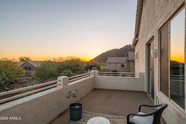 balcony at dusk featuring a mountain view