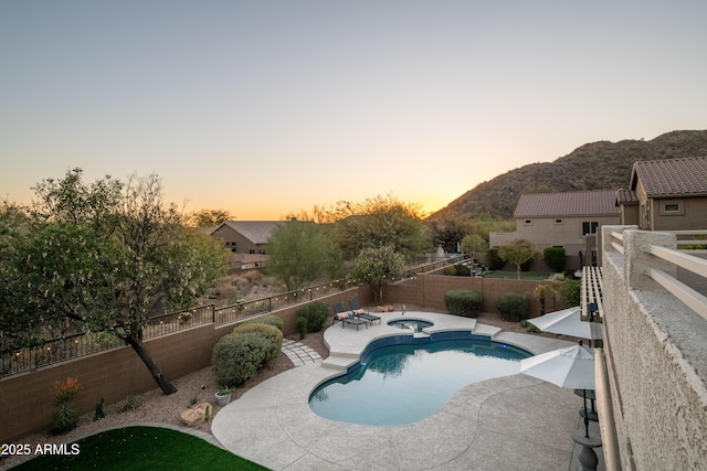 pool at dusk with a patio and a mountain view