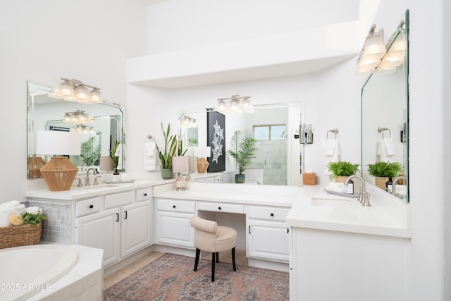 bathroom with vanity and tiled tub