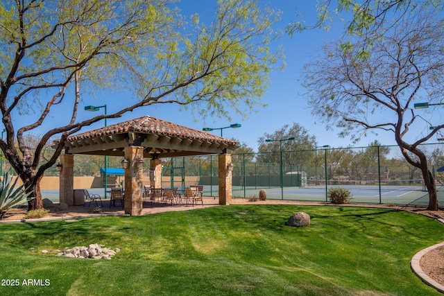 view of property's community featuring a yard, tennis court, and a gazebo