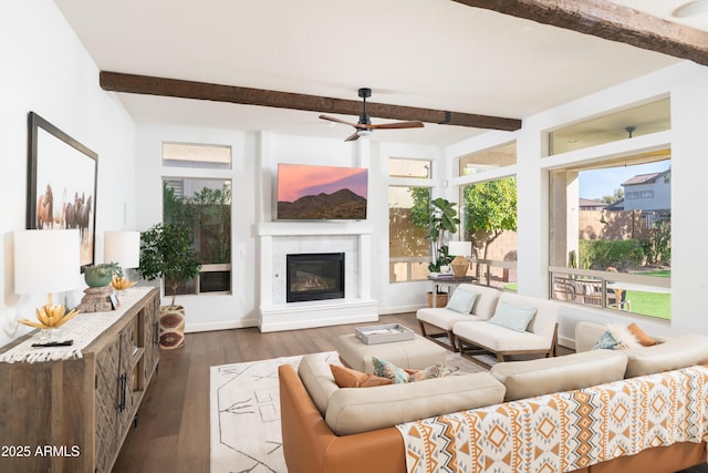 living room featuring ceiling fan, dark wood-type flooring, and beamed ceiling