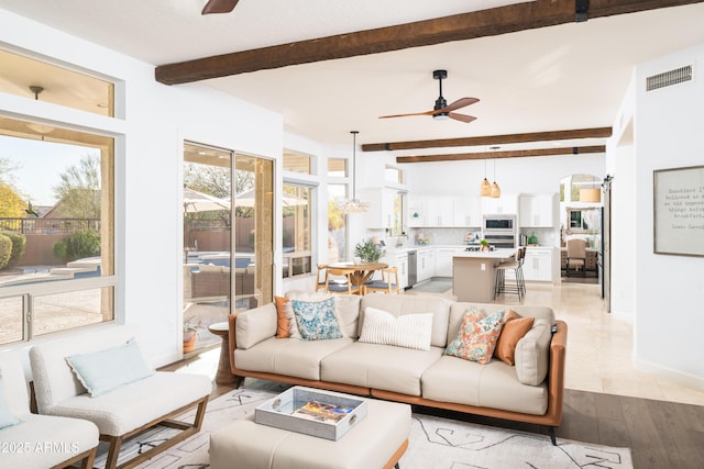 living room with beam ceiling, ceiling fan, and light wood-type flooring