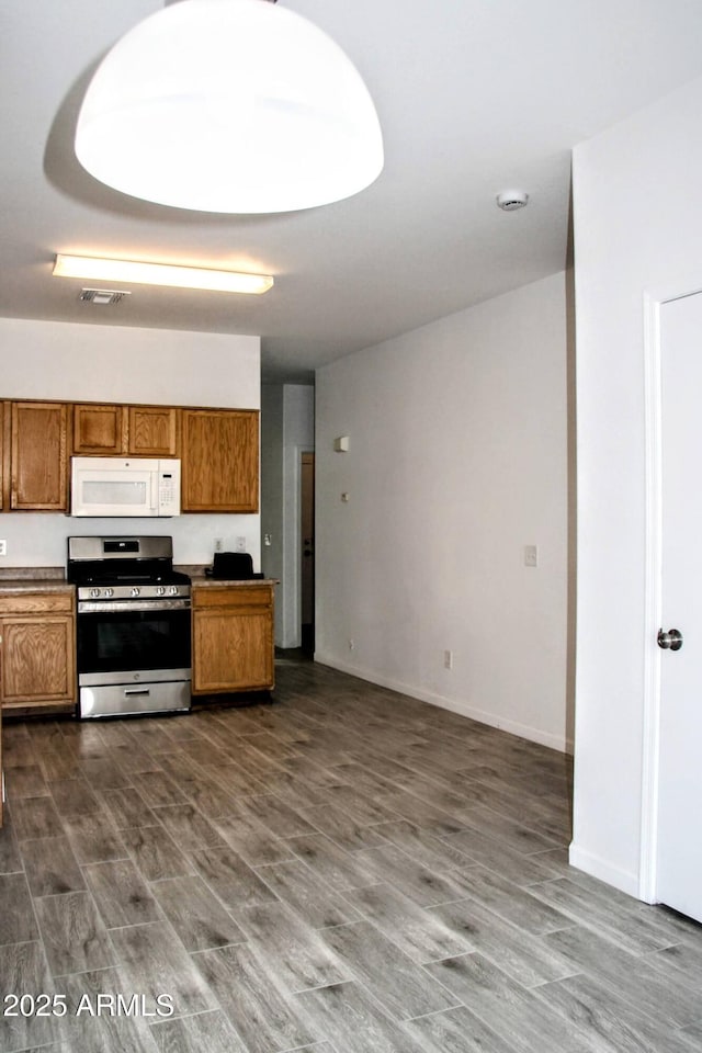 kitchen with dark hardwood / wood-style flooring and stainless steel stove