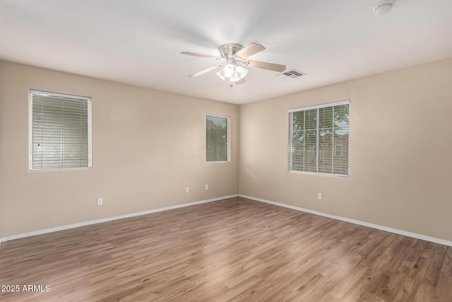 10 N 87th Dr, Tolleson, AZ 85353 - empty room featuring light wood-style floors, ceiling fan, baseboards, and a smoke detector