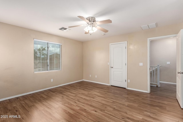 10 N 87th Dr, Tolleson, AZ 85353 - spare room with wood finished floors, ceiling fan, and baseboards