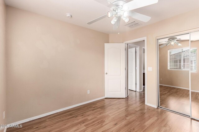 10 N 87th Dr, Tolleson, AZ 85353 - unfurnished bedroom featuring light wood-type flooring, a closet, baseboards, and a ceiling fan