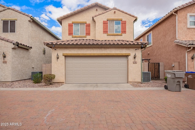 10 N 87th Dr, Tolleson, AZ 85353 - mediterranean / spanish-style house featuring a garage, driveway, a tiled roof, and stucco siding