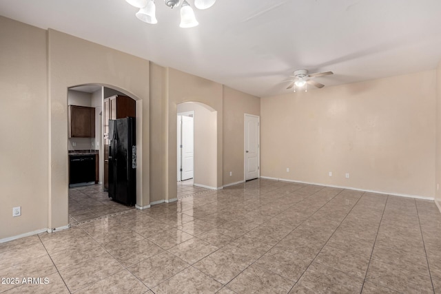 10 N 87th Dr, Tolleson, AZ 85353 - unfurnished room with arched walkways, a ceiling fan, light tile patterned floors, and baseboards