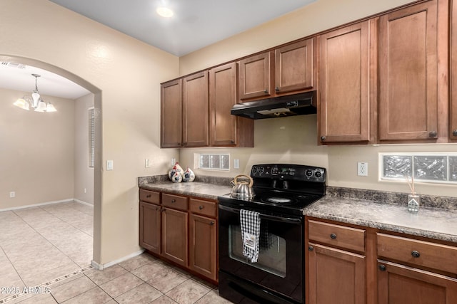 10 N 87th Dr, Tolleson, AZ 85353 - kitchen featuring electric range, under cabinet range hood, dark countertops, arched walkways, and light tile patterned floors