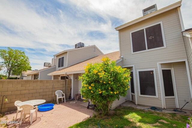 rear view of property with fence, a patio, and cooling unit