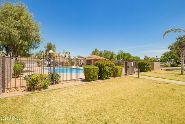 view of swimming pool with a lawn, fence, and a fenced in pool