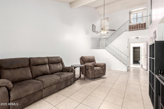 living room with light tile patterned flooring, ceiling fan, high vaulted ceiling, beamed ceiling, and stairway