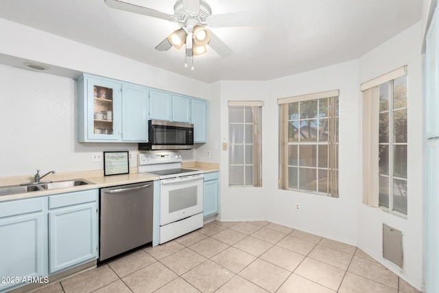 kitchen with a sink, light countertops, stainless steel appliances, and blue cabinetry