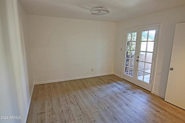 unfurnished room featuring french doors and light hardwood / wood-style flooring