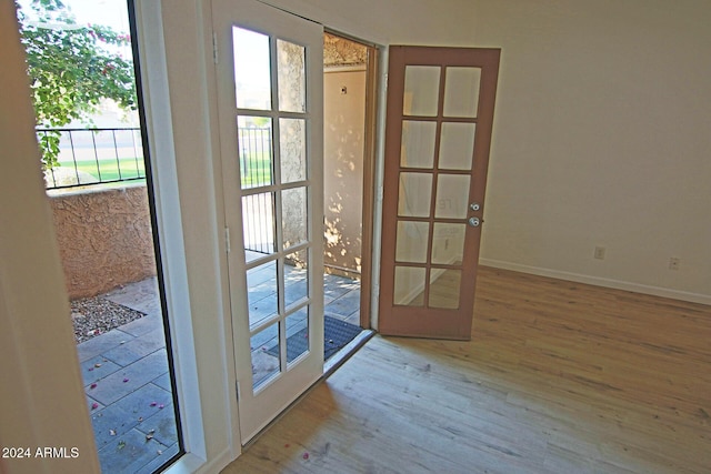 doorway to outside featuring a healthy amount of sunlight, french doors, and light hardwood / wood-style floors