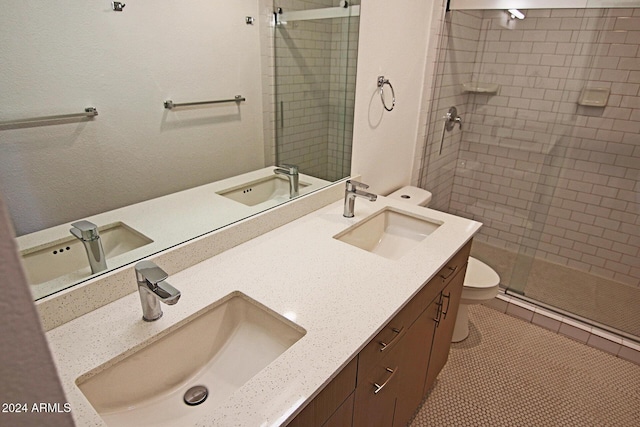 bathroom with toilet, walk in shower, vanity, and tile patterned flooring