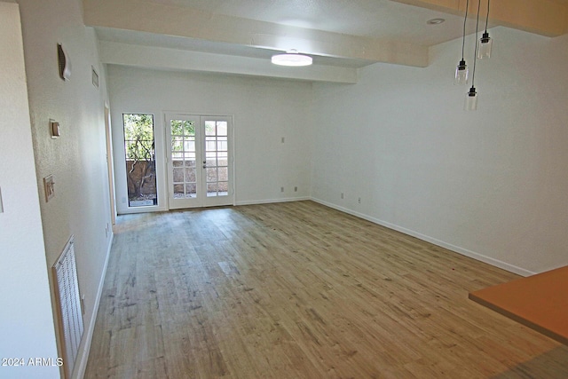 spare room with french doors, beamed ceiling, and light hardwood / wood-style flooring