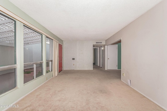 carpeted spare room with a textured ceiling