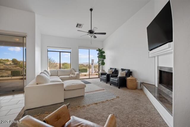 living room featuring ceiling fan, carpet, and lofted ceiling