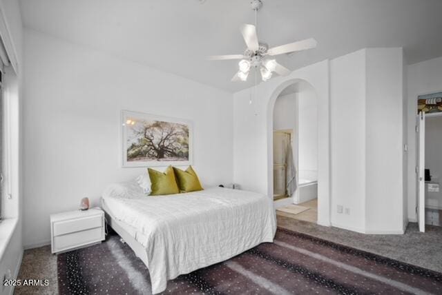 bedroom with ceiling fan, connected bathroom, and carpet flooring