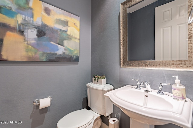 bathroom featuring tasteful backsplash, sink, and toilet