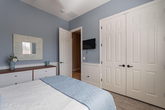 bedroom featuring light carpet and a closet