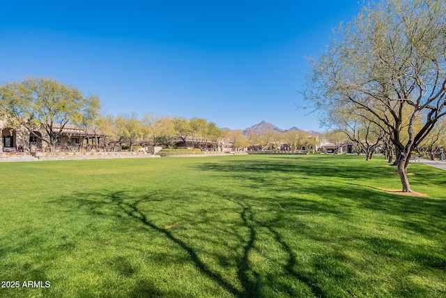 view of home's community with a mountain view and a lawn