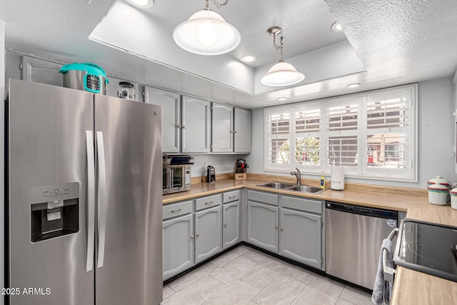 5221 W Garden Dr, Glendale, AZ 85304 - kitchen with light countertops, a sink, stainless steel appliances, a raised ceiling, and gray cabinetry