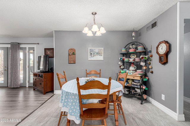 5221 W Garden Dr, Glendale, AZ 85304 - dining area featuring baseboards, an inviting chandelier, a textured ceiling, visible vents, and light wood finished floors