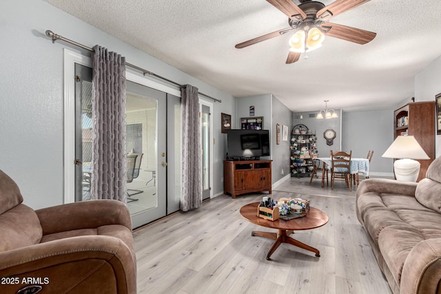 5221 W Garden Dr, Glendale, AZ 85304 - living area featuring ceiling fan with notable chandelier, light wood-style flooring, and a textured ceiling
