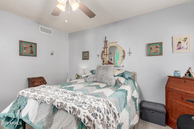 5221 W Garden Dr, Glendale, AZ 85304 - bedroom featuring a textured ceiling, light wood finished floors, ceiling fan, and visible vents