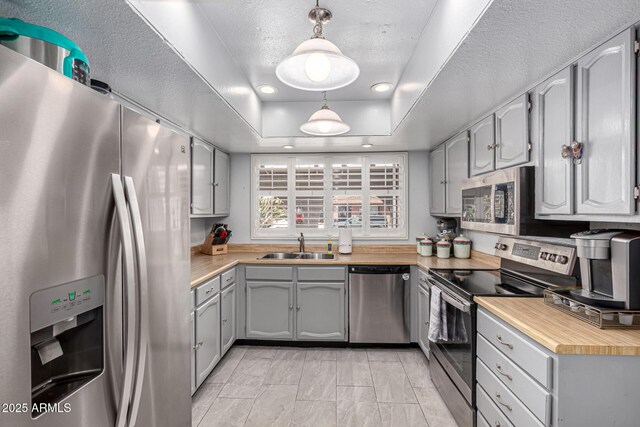 5221 W Garden Dr, Glendale, AZ 85304 - kitchen featuring gray cabinets, appliances with stainless steel finishes, a sink, light countertops, and a raised ceiling