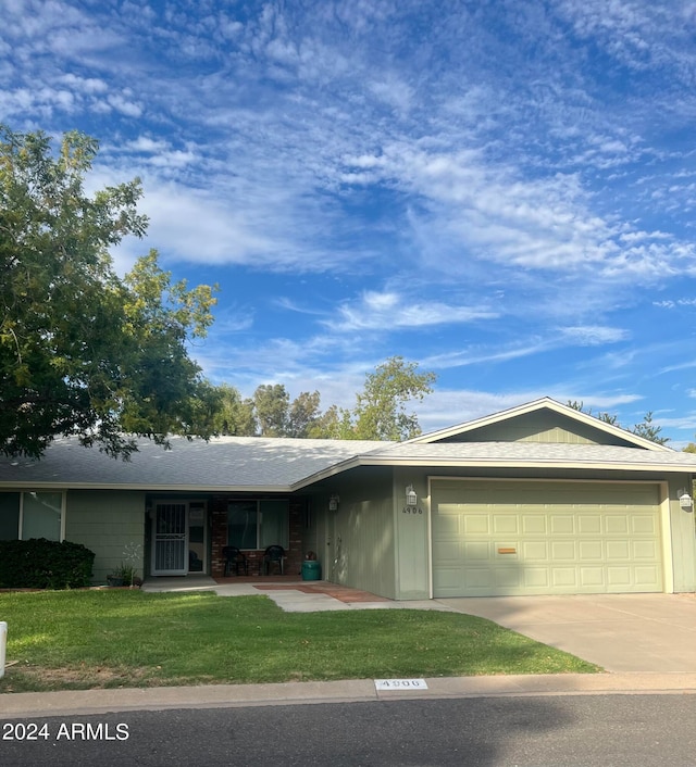 ranch-style house with a garage and a front lawn