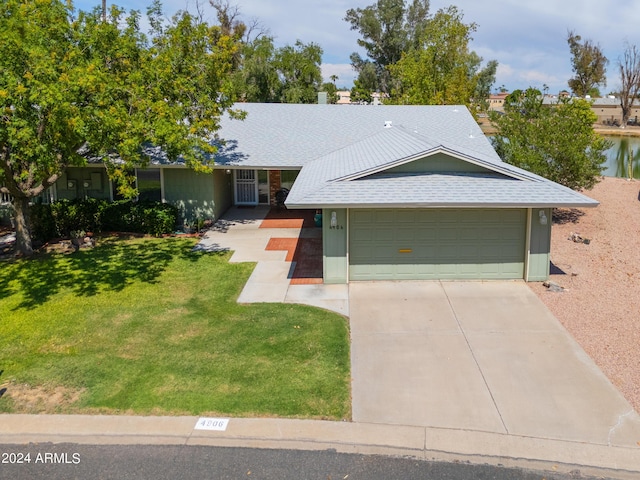 single story home with driveway, a garage, a front lawn, and roof with shingles