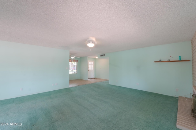 empty room featuring a textured ceiling, carpet floors, and visible vents