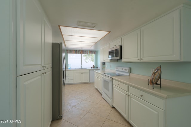 kitchen with white cabinets, light tile patterned flooring, and stainless steel appliances