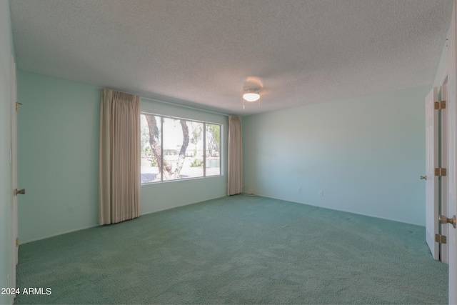 spare room with carpet and a textured ceiling