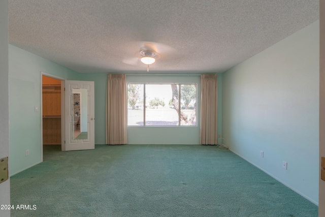 carpeted spare room featuring a textured ceiling