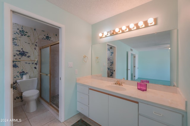 bathroom with an enclosed shower, vanity, toilet, and a textured ceiling