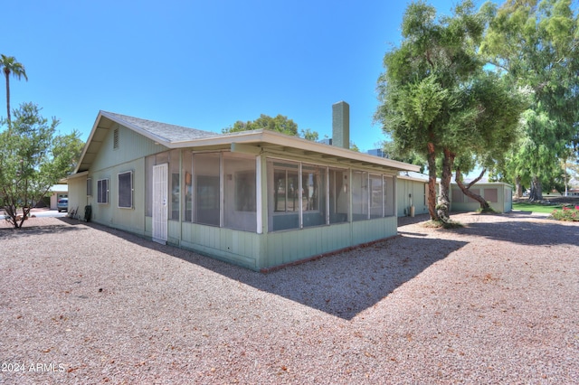 back of property with a sunroom