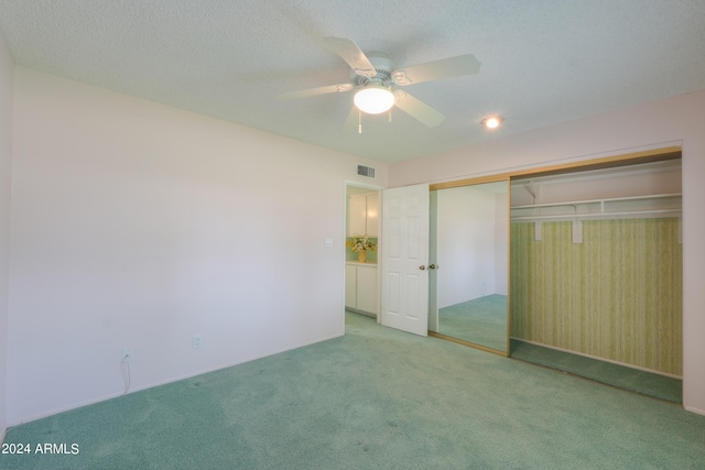 unfurnished bedroom featuring carpet floors, a closet, visible vents, and a textured ceiling