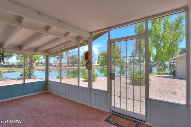 unfurnished sunroom featuring a water view and plenty of natural light