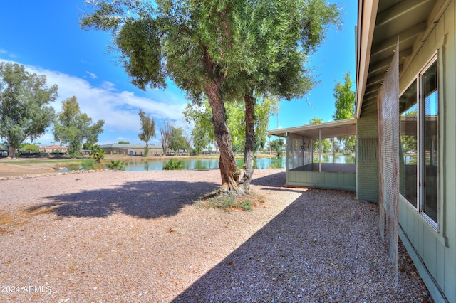 view of yard with a water view and a sunroom